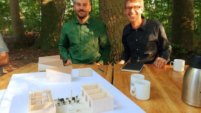 Arkitekt Fredrik Petterson og hans assistent Scott præsenterer spejderhusprojektet i form af en fysisk model i træ og pap.